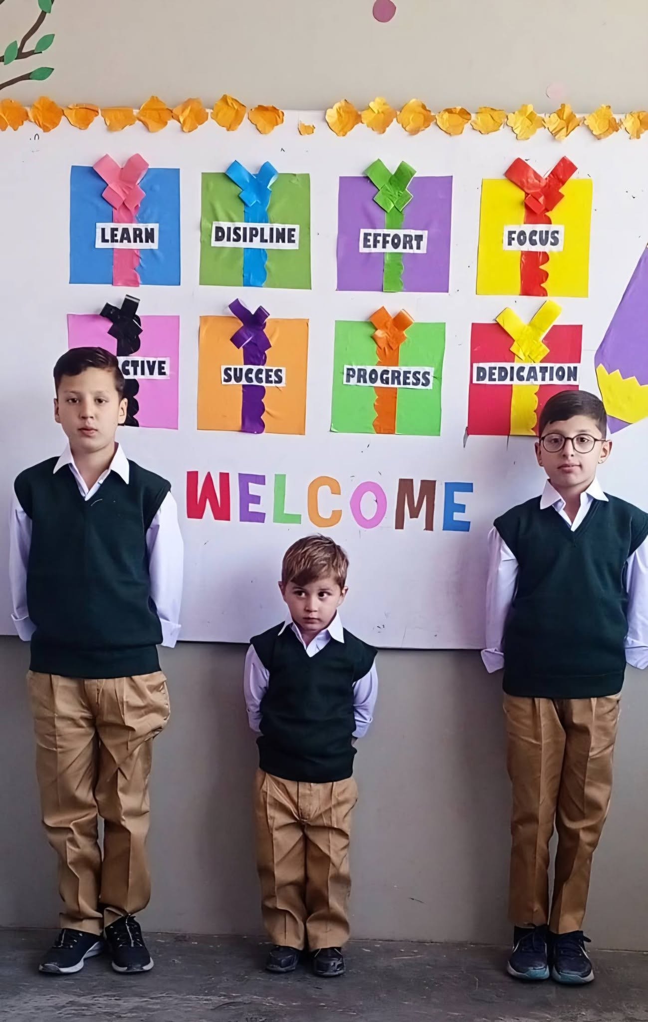 Olive Green students beside a colourful welcome display board